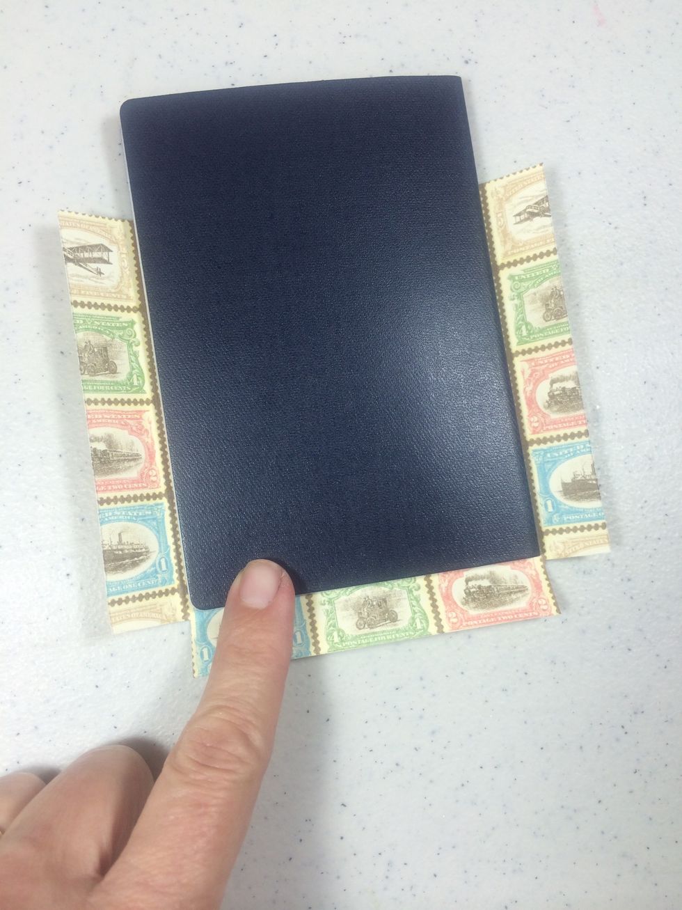 Flip the paper face down and lay your passport on top leaving 1/2" space on the right, bottom and left sides. Snip away the two bottom corners.