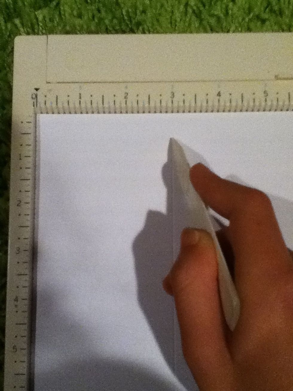 Flip the paper face down on the scoring board, and score at three inches. If you don't have a scoring board, you can still score the paper at three inches using a ruler.
