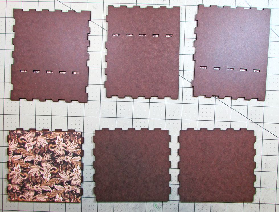 Flip the pieces over so the right sides are showing. Use a craft knife to cut out the tab openings in the side pieces. Attach paper to the shelf piece.