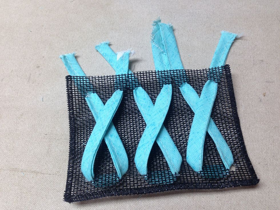 Flip the pocket over and thread the utensil strips through the opposite hole \u2013 front to back - to form a criss-cross as shown making sure to cross the same strip on top \u2013 left over right.