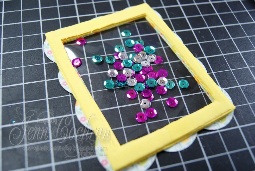 Flip your frame over and add sequins on top of the acetate window.