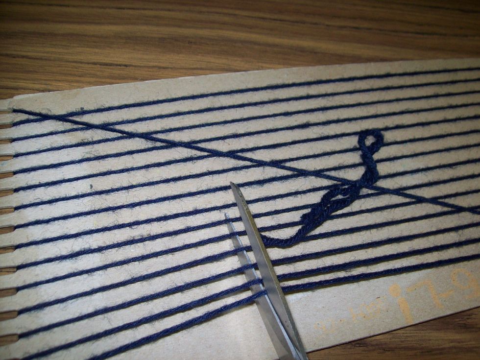 Flip your loom over and cut the warp off of the loom.