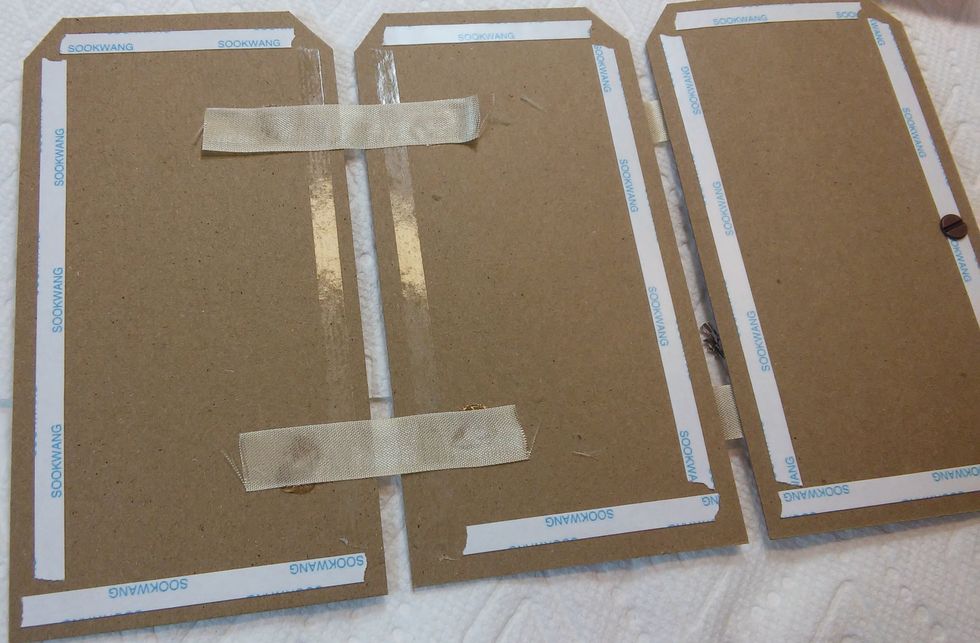 Flipped over, I'll do the same thing as I did for the front side. Make a couple ribbon hinges, add fabritac and the tags...