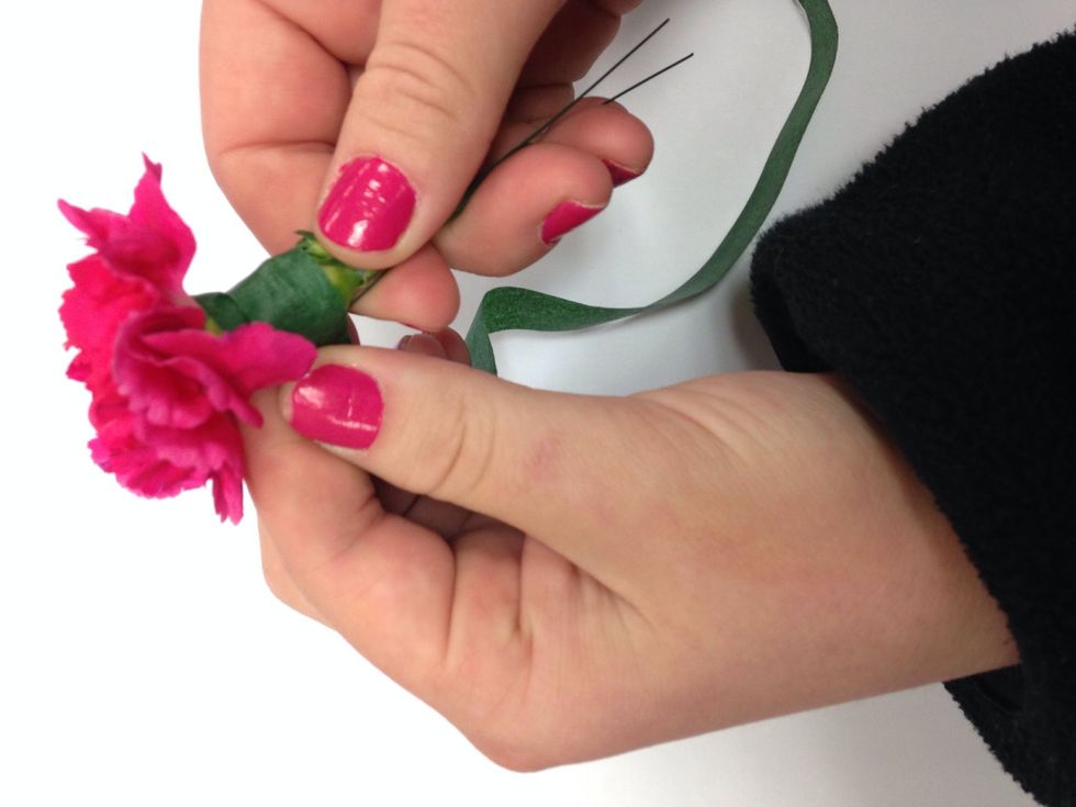 Floral tape the carnation. Put tape in between thumb and pointer finger, pull tightly and you move down the stem.