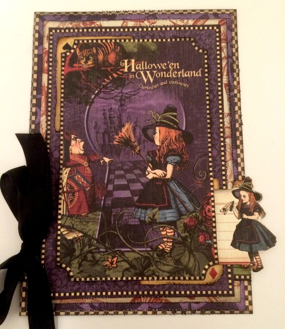 Foam square the Alice tag an 1" from the bottom of the checker paper. She sits right to the edge of card. Foam square Hallowe'en in Wonderland piece & place overtop of the already adhered one.