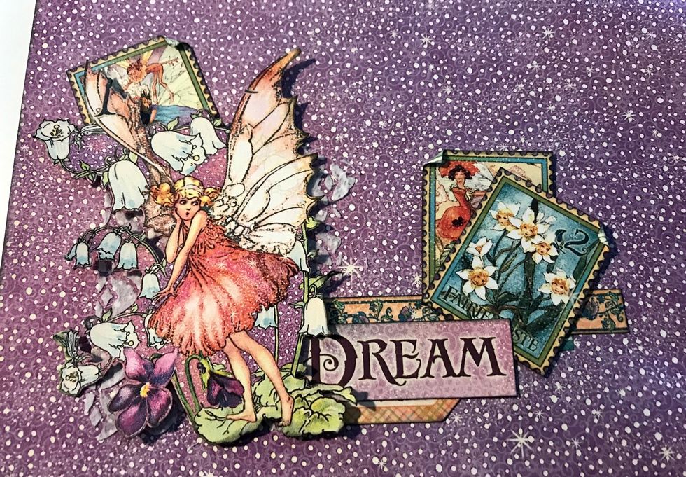 Foam square the fairy to the left of the dream word. Adhere 1 stamp in the top left corner of fairy. Adhere 2 stamps to the right of the Dream word. Roll one corner down on each stamp.