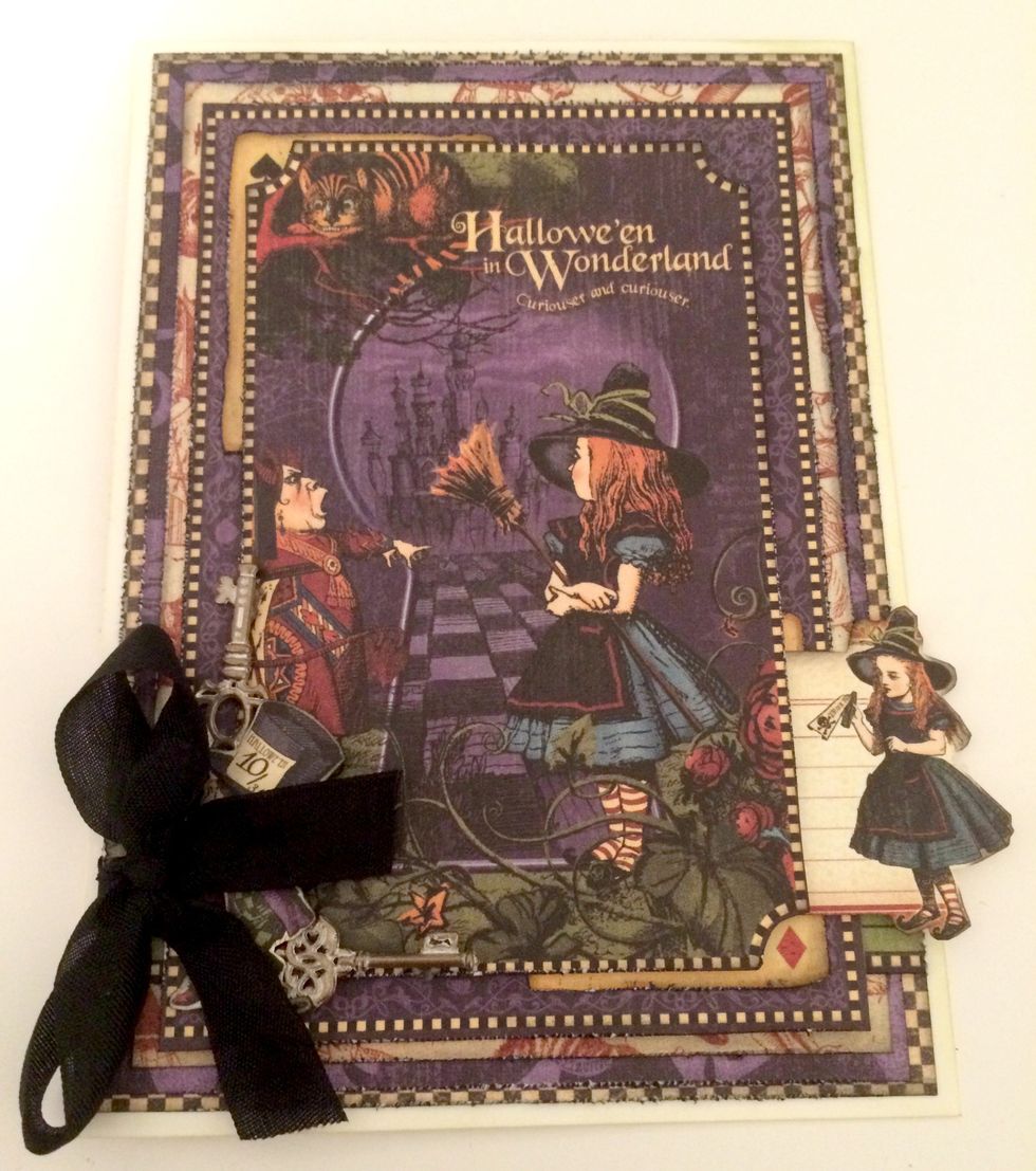 Foam square the mad hatter in the bottom left hand corner of cut out Hallowe'en card. Add glue dots to keys & adhere one to the right & one to the left of mad hatter. Adhere card front to card base.