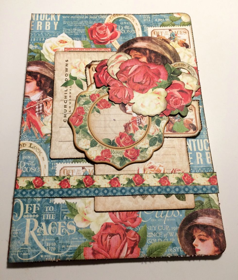 Foam square the rose with leaf, a set of three roses, two white roses and a medium red rose in the top right hand corner as desired, filling in the holes between the lady, stamps and chipboard piece.