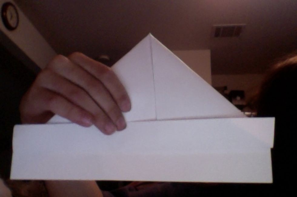 Fold 1 side at the bottom up to touch the corners of your triangles.