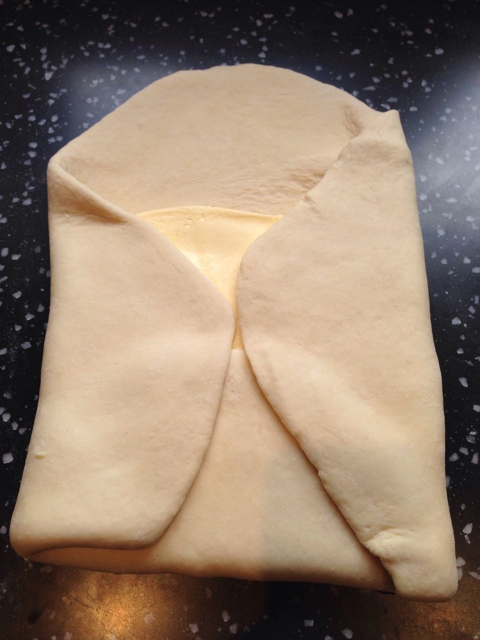 Fold a flap of dough over the butter so the point of the dough reaches the centre of the butter slab. Do the same with the remaining 3 sides. Flatten the dough with your palm gently to seal the seams