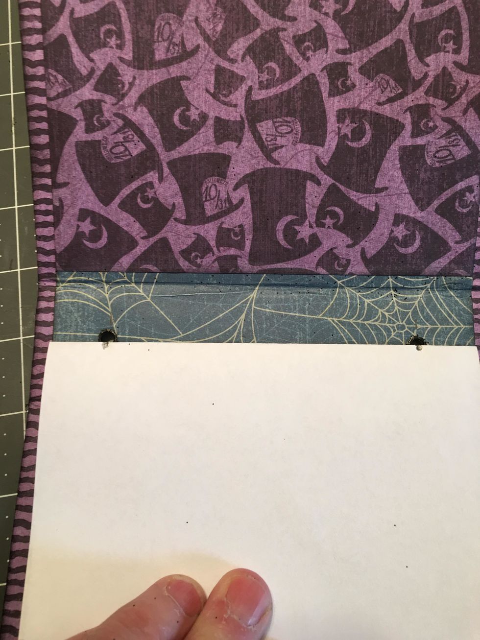 Fold a piece of lightweight paper in half, line up the fold with the eyelet holes in the spine of the cover and mark with a pencil to create a template.