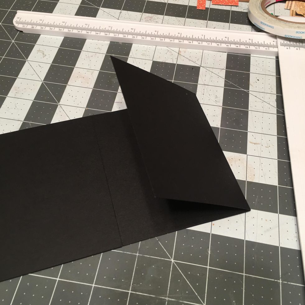 Fold and burnish the score lines of the long page section so that each side folds into the hinge piece with the 1/2" spine section in the center.