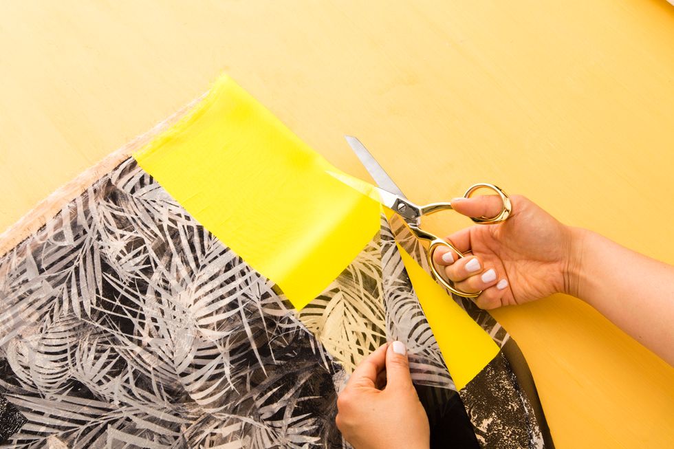 Fold and cut your colored or printed fabric in half. Pin one piece of printed fabric (the shorter end) to the smaller end of your V on the muslin fabric. Do this on both sides.