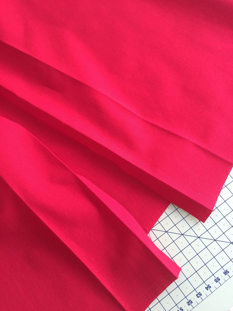Fold and iron 1/2 inch then 2 inch for pockets , at top and bottom of the 41 inch red fabric