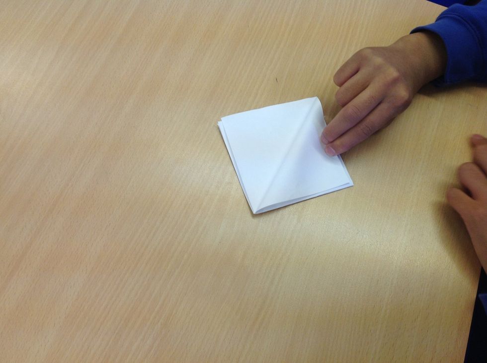 Fold back one of the flaps of paper to the other corner.