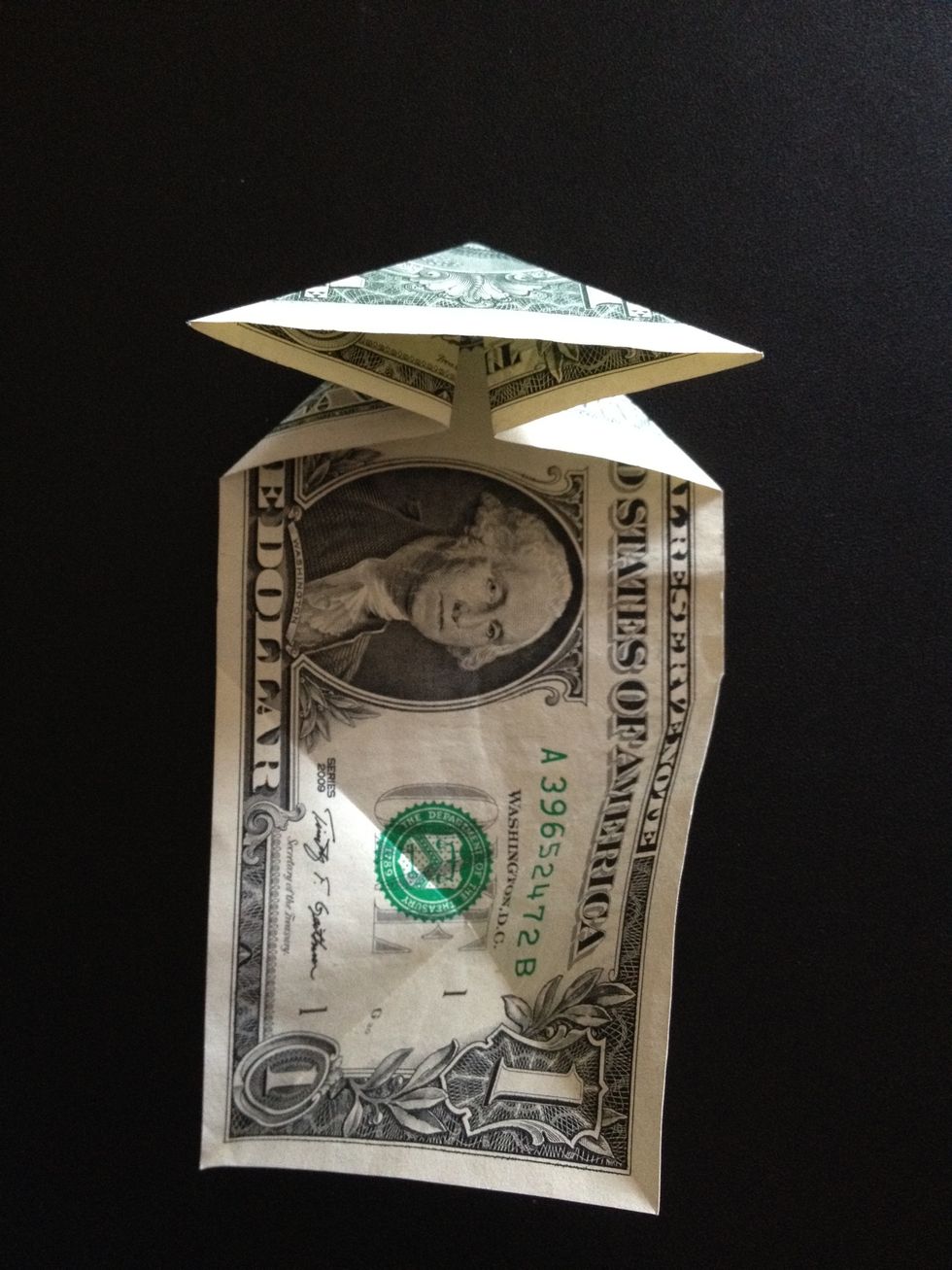 Fold both ends of the bill by pulling in the sides, in order to have the shape of a triangle