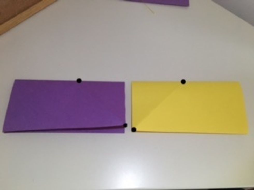 Fold both papers down "hotdog" style so they look like this. The top sides should meet the bottom sides. These black dots show the endpoints of the previous ceases. They should still be mirror images.