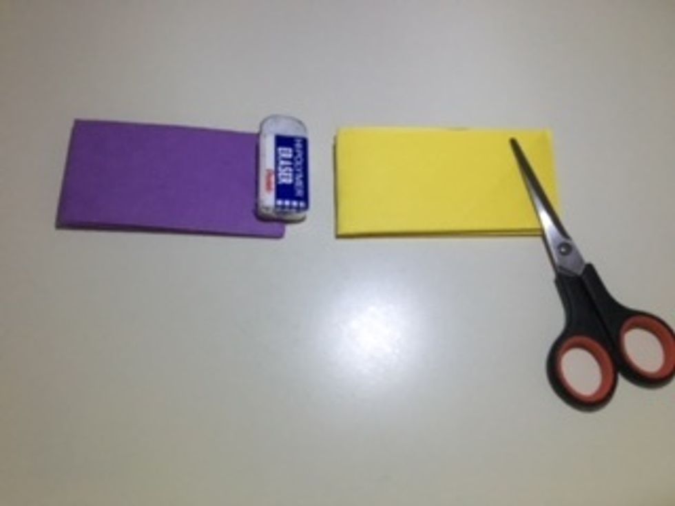 Fold both sheets "hamburger style" so the left sides meet the right. (Again, the eraser and scissors are only there to hold it down so it is easier to see).