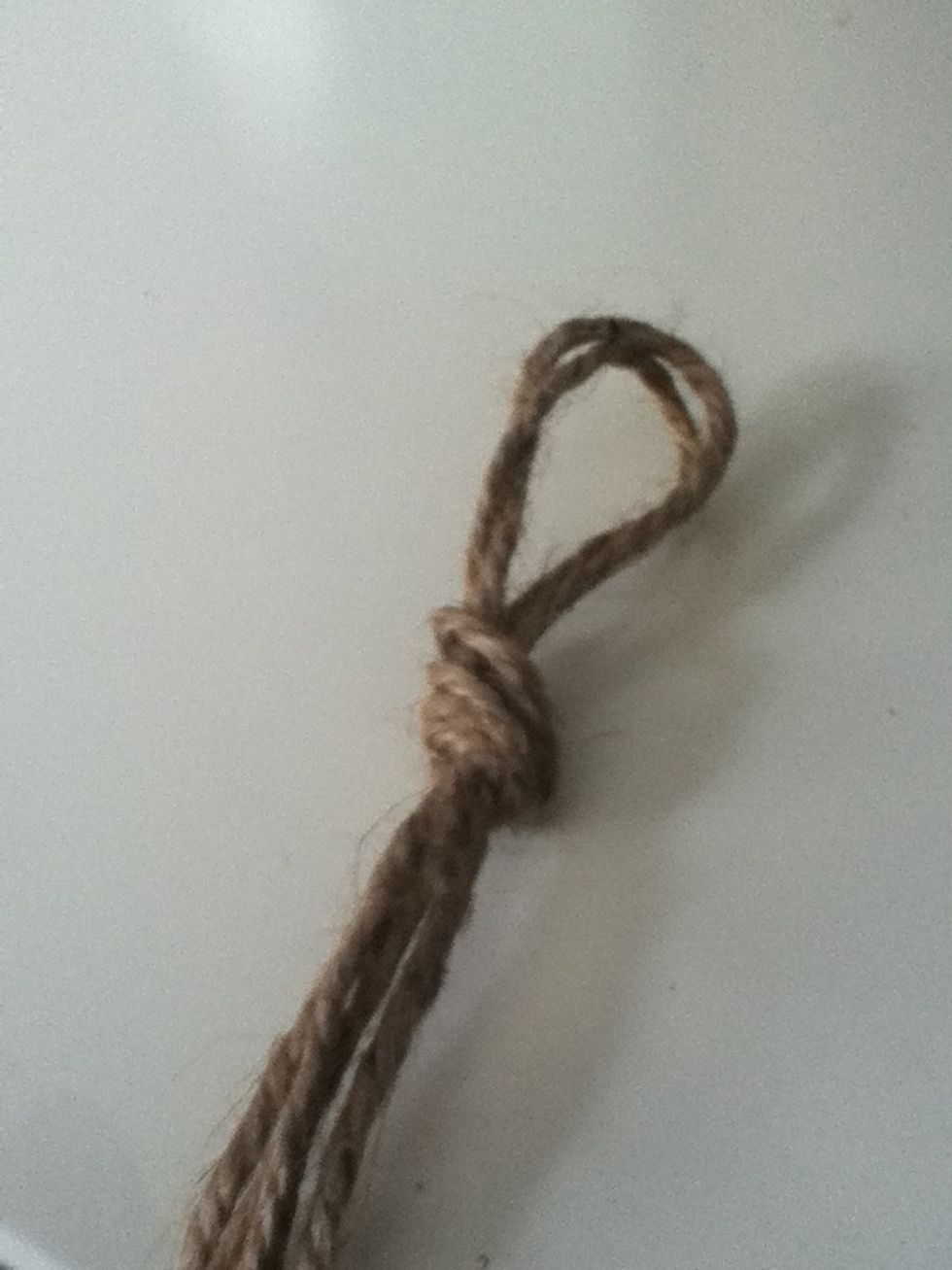 Fold both strings in half and then tie together. Make sure the smaller strings are in the middle.