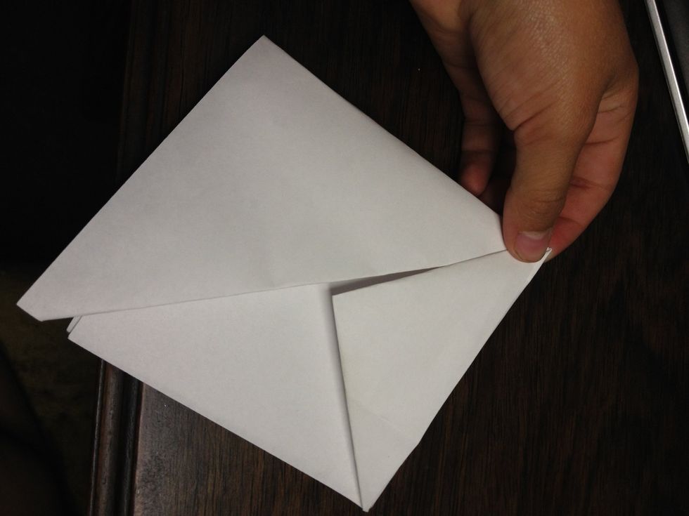 Fold bottom corners as the picture shows then continue this with the other side