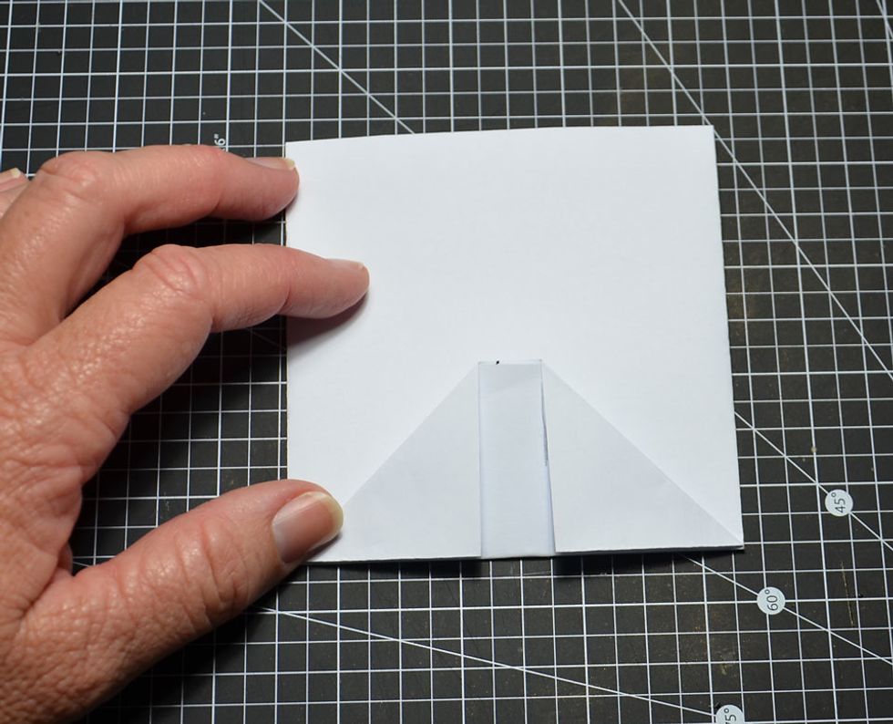 Fold bottom up so it lines up with fold edges from the other side as shown.