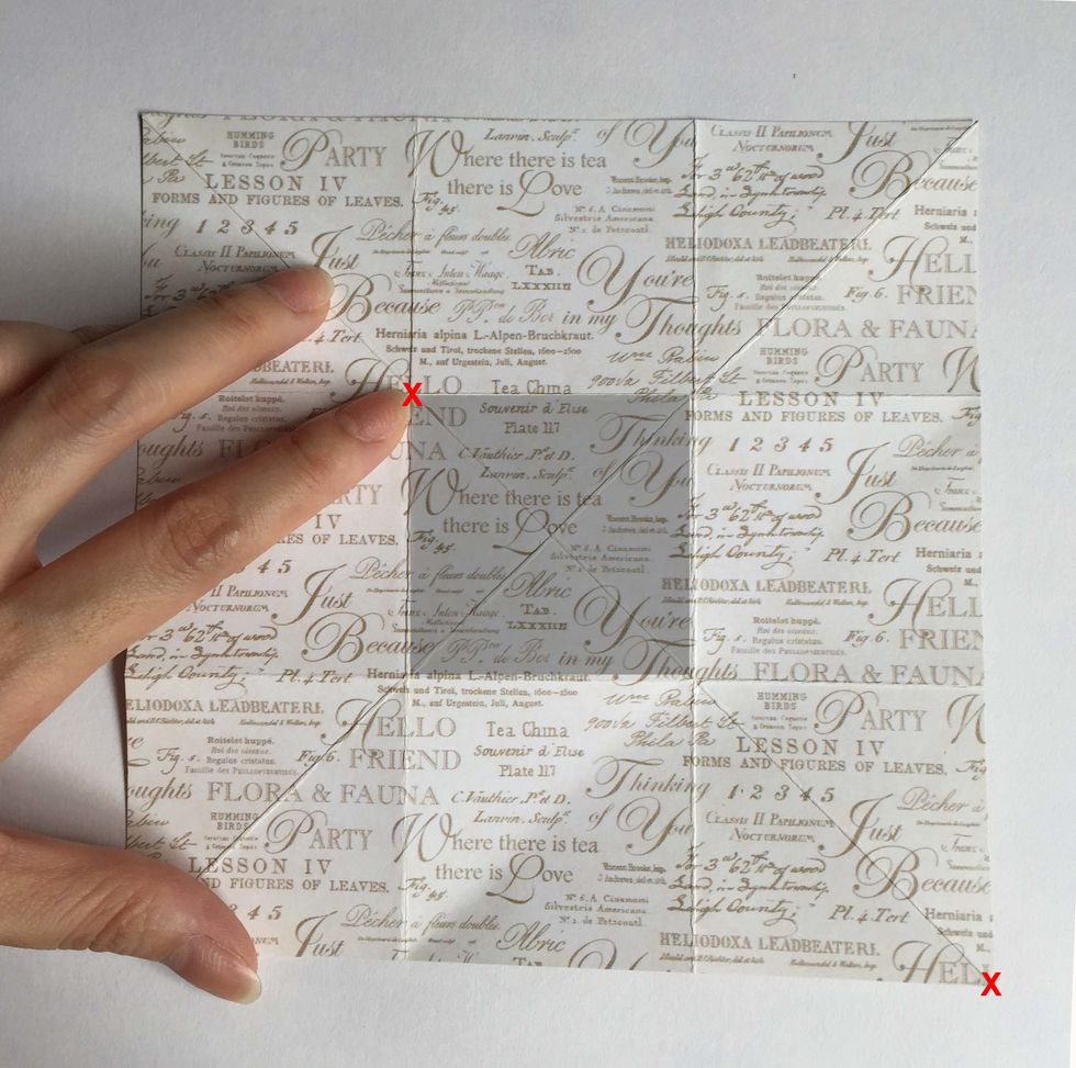 Fold diagonally across from the bottom right hand corner of the paper (red x) towards where my index finger (red x) is pointing at the top left hand corner of the gray shaded box...