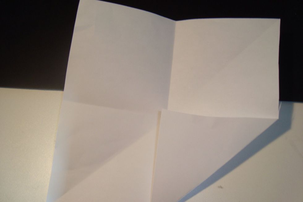 Fold each corner towards the centre along the crease lines.