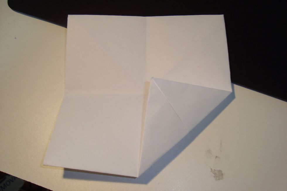 Fold each corner towards the centre along the crease lines.