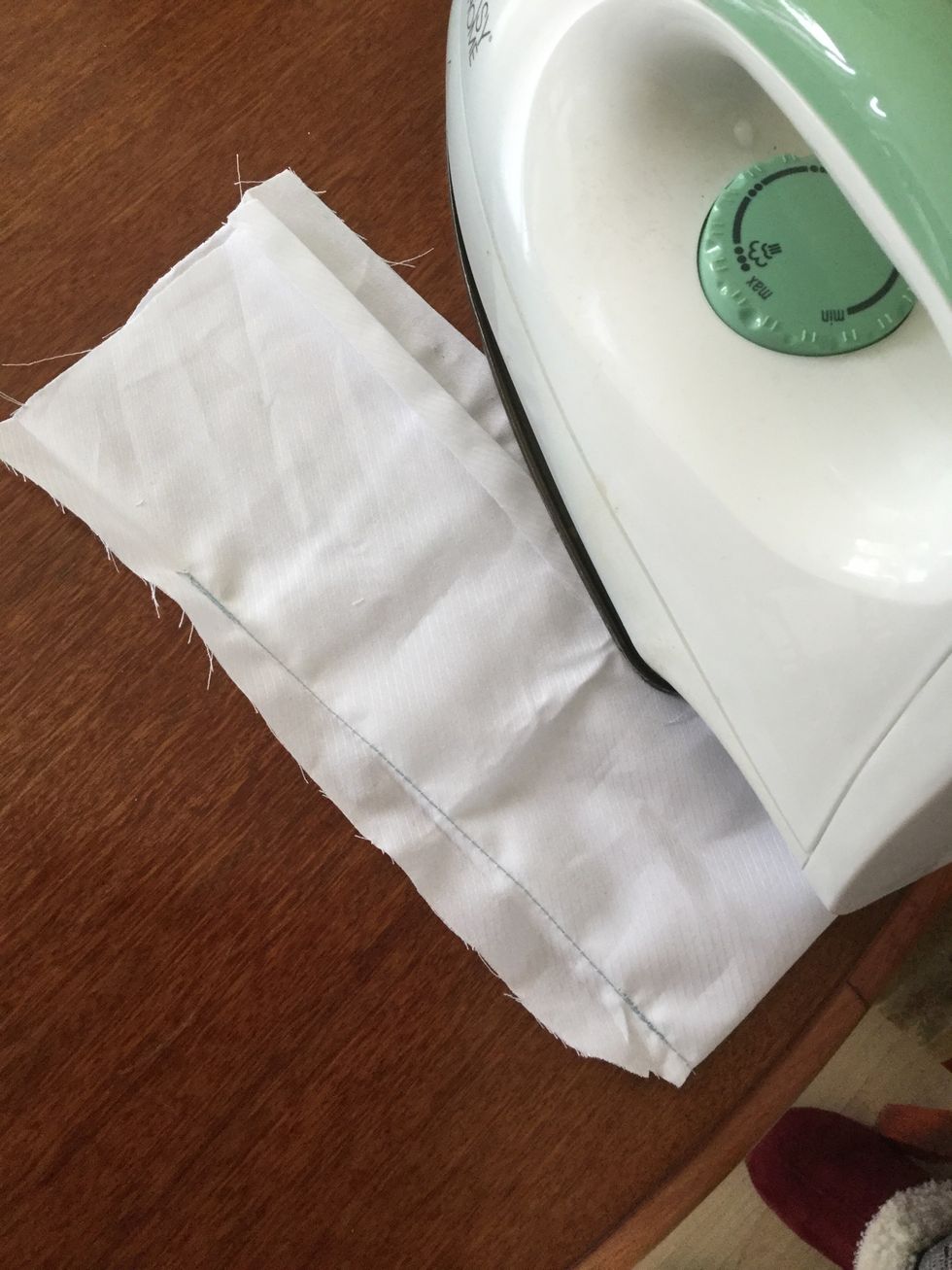 Fold each side over on opposite sides and press with the iron. Do this on both bits of material.
