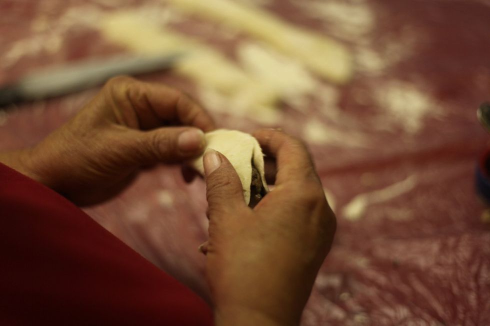 Fold in half and press the top together so it sticks together. You don't need to use water to glue the dough together.