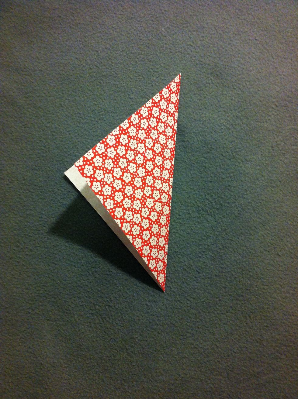 Fold in half diagonally, making sure to crease well. It's easier to fold on a hard surface, although professionals can fold in mid-air