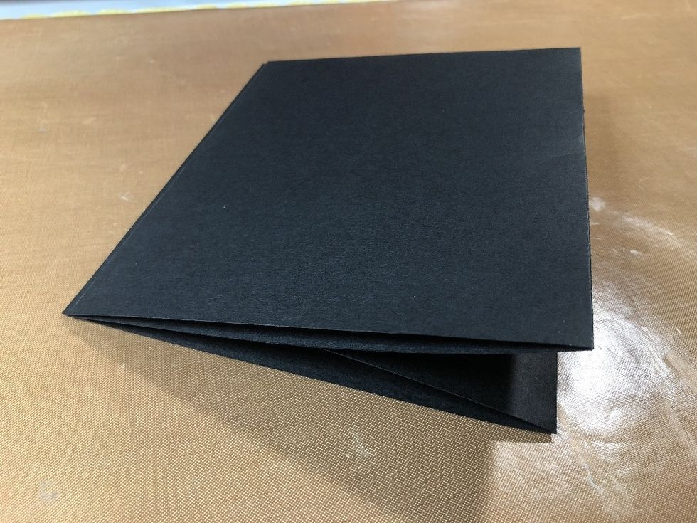 Fold in half, so both smaller panels lay flat. Remove the tape backings and attach your pocket flush on top of the panels.