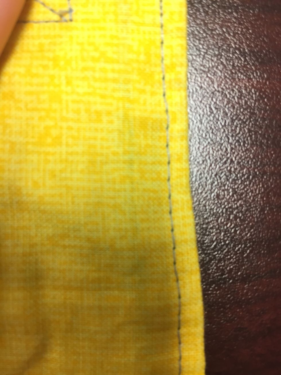 Fold in the fabric around the opening to make it match with the shape around it. Top stitch around the edge of the ear bud holder at \u00bc of an inch to close the opening and finish the edges.