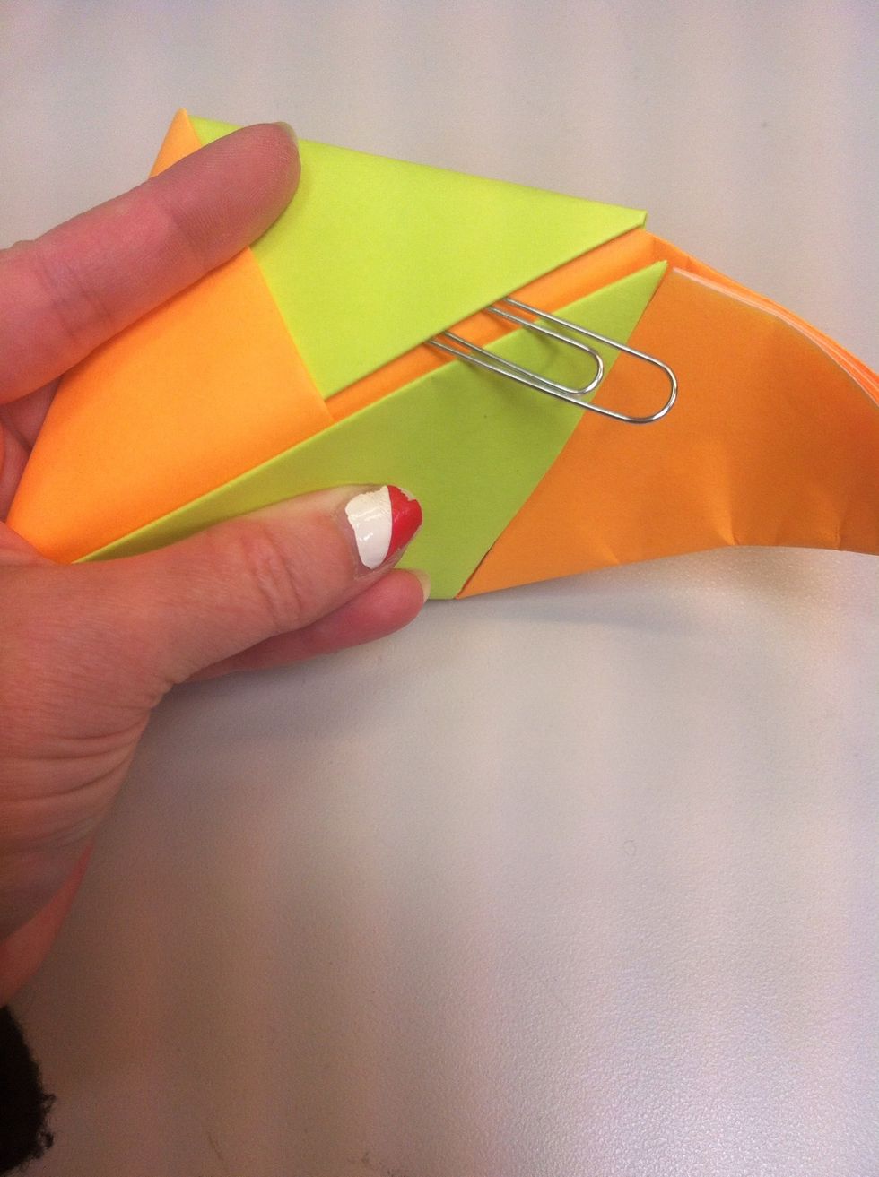 Fold it back to that pocket where paper clip is & stick orange triangle in it...