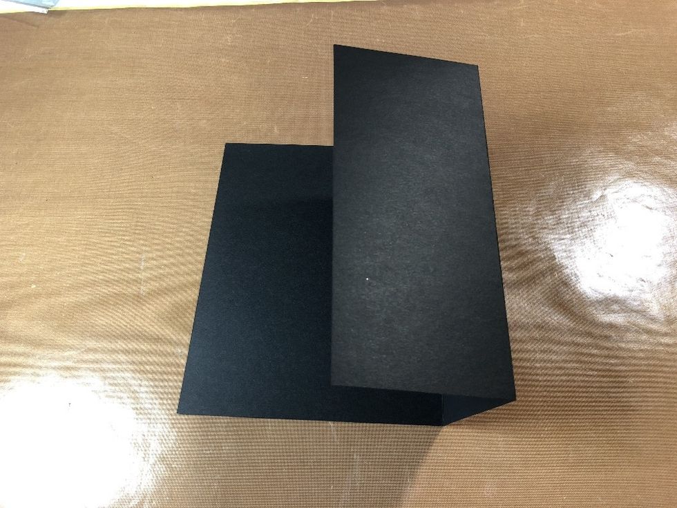 Fold on the score lines. You now have two small panels and one larger one.