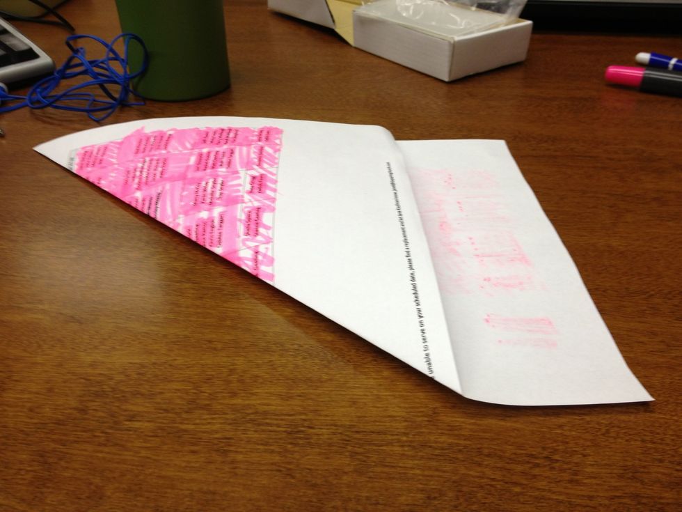 Fold one corner of the paper down to form a triangle with a small piece at the end.