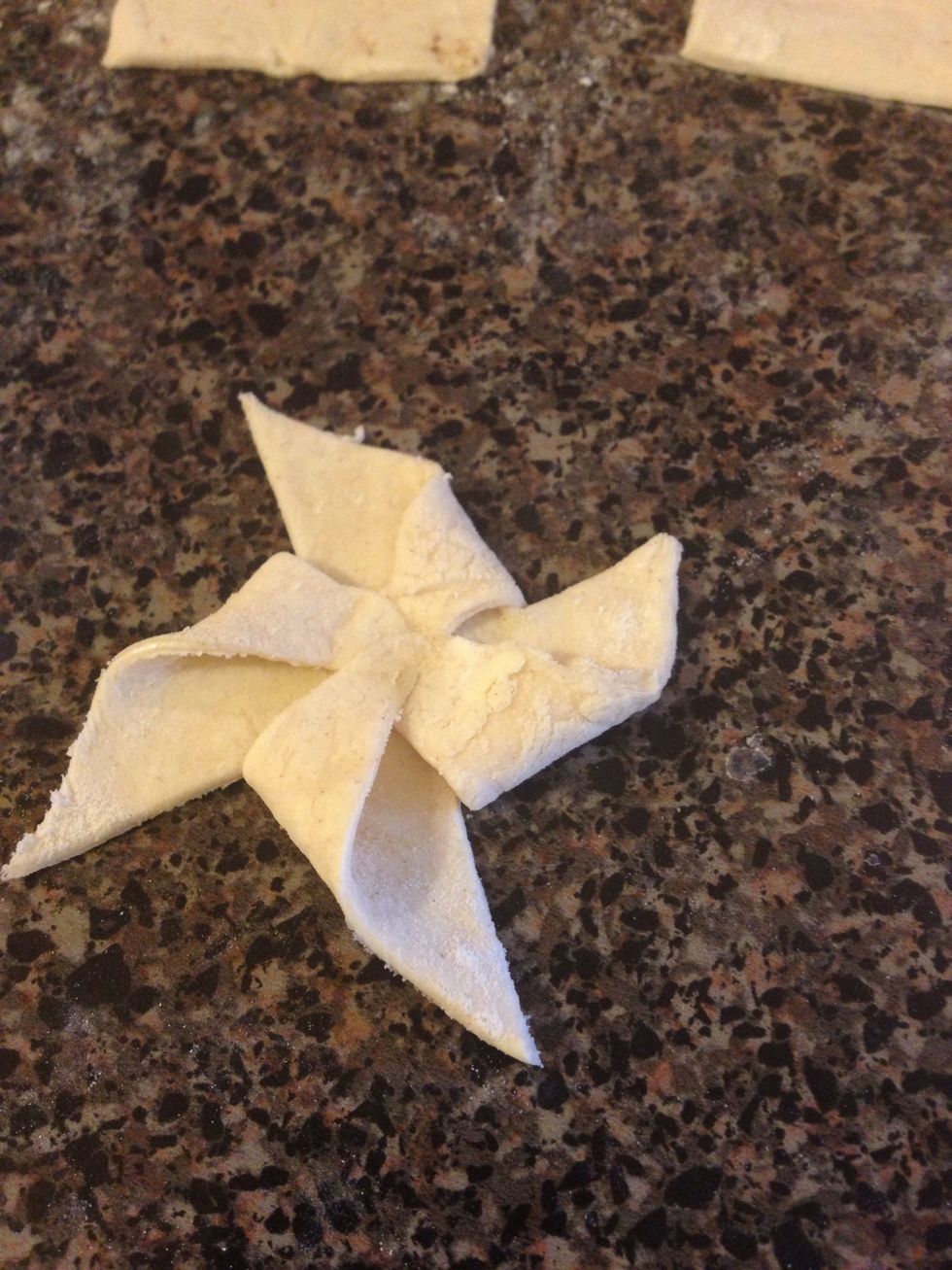 Fold one corner on each side to the center. Make sure you press on the center so the dough won't move.