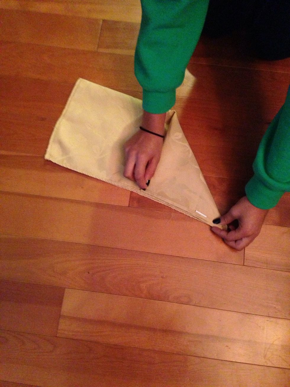 Fold one corner upwards towards the middle.