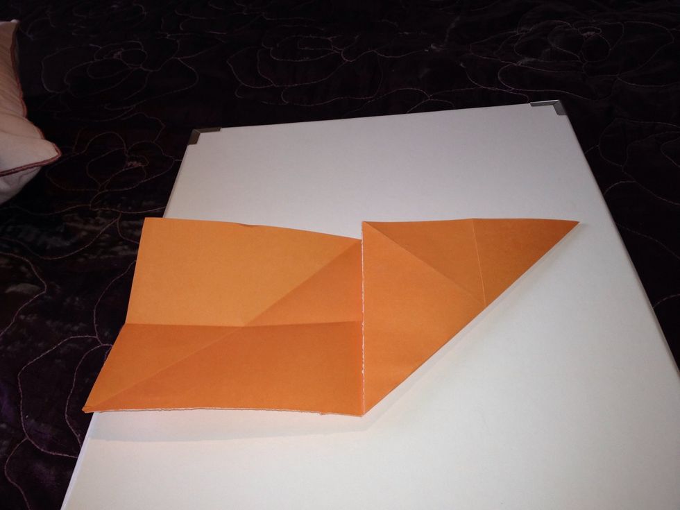 Fold one end to meet the middle so that you have a square with 2 lines across the middle.