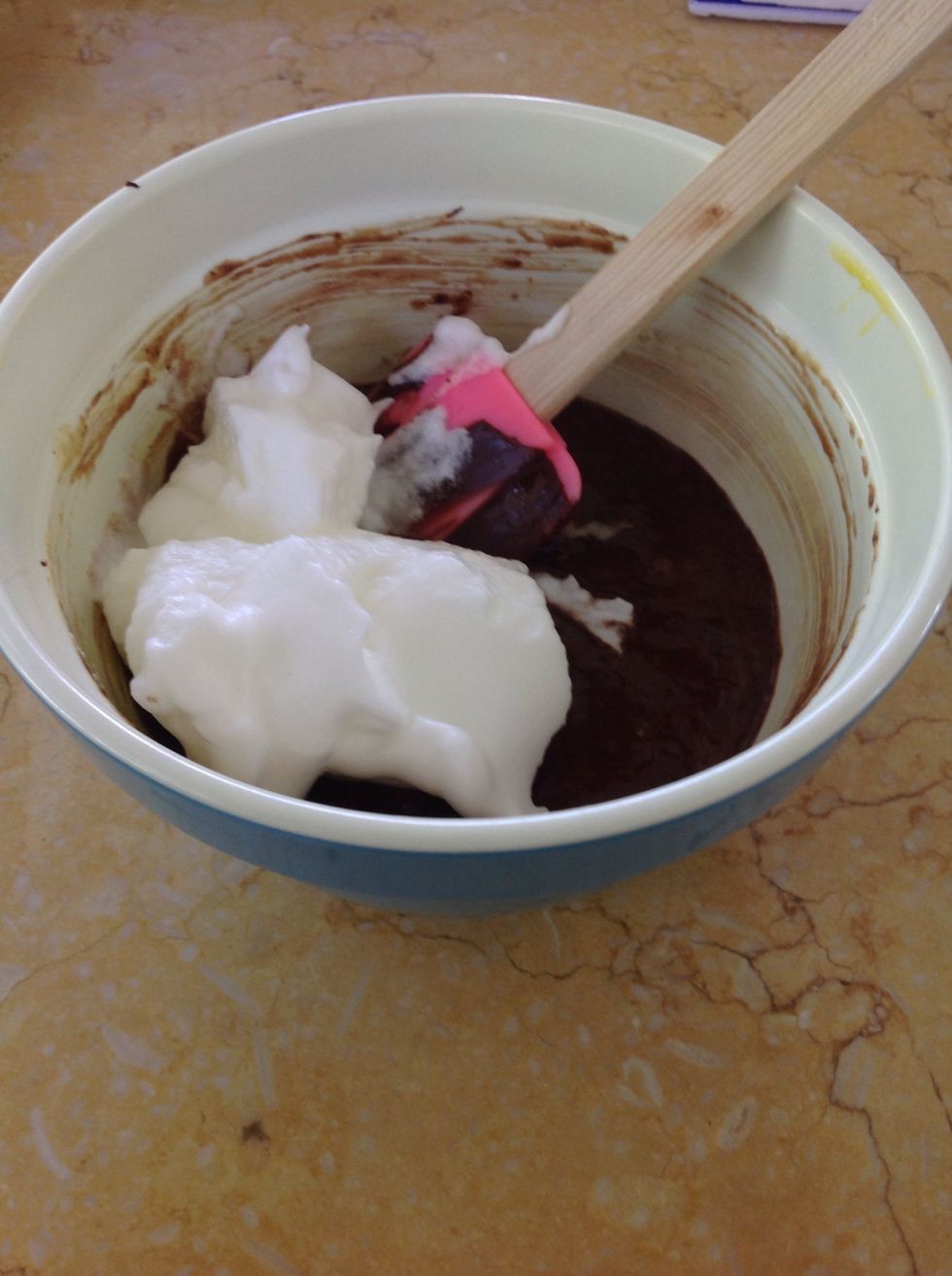 Fold one-fourth of the beaten egg whites into the chocolate mixture to lighten it.