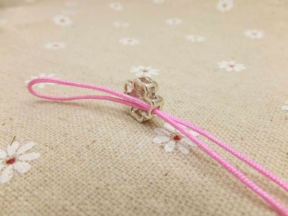 Fold one of the peach cord in half and take it through the hole of Silver Mosaic Four-leaf clovers Bead.