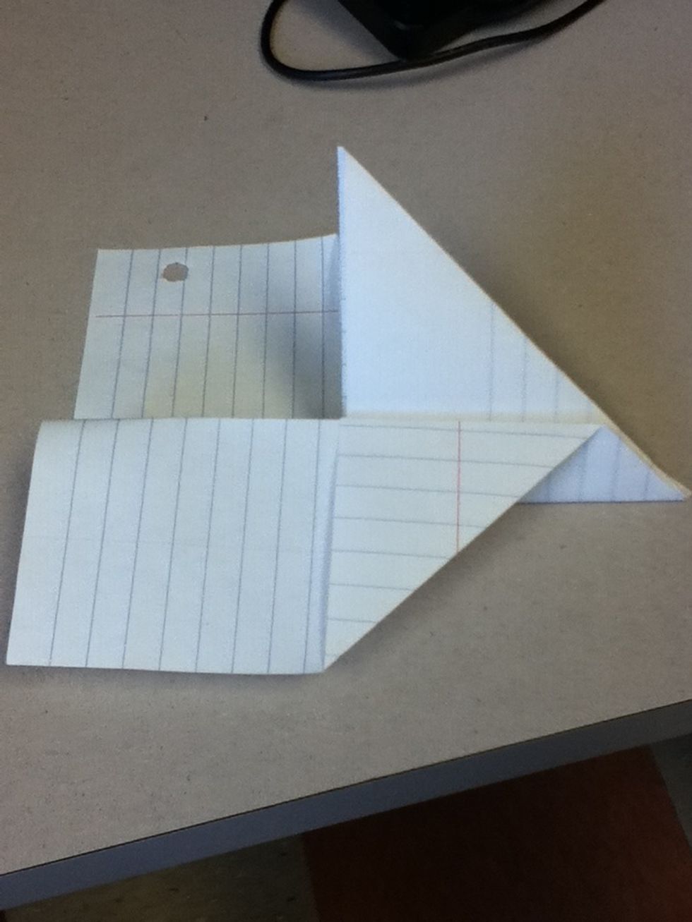 Fold one side of the plane to form the wing, but still leaving a shark-like fin sticking up in the middle