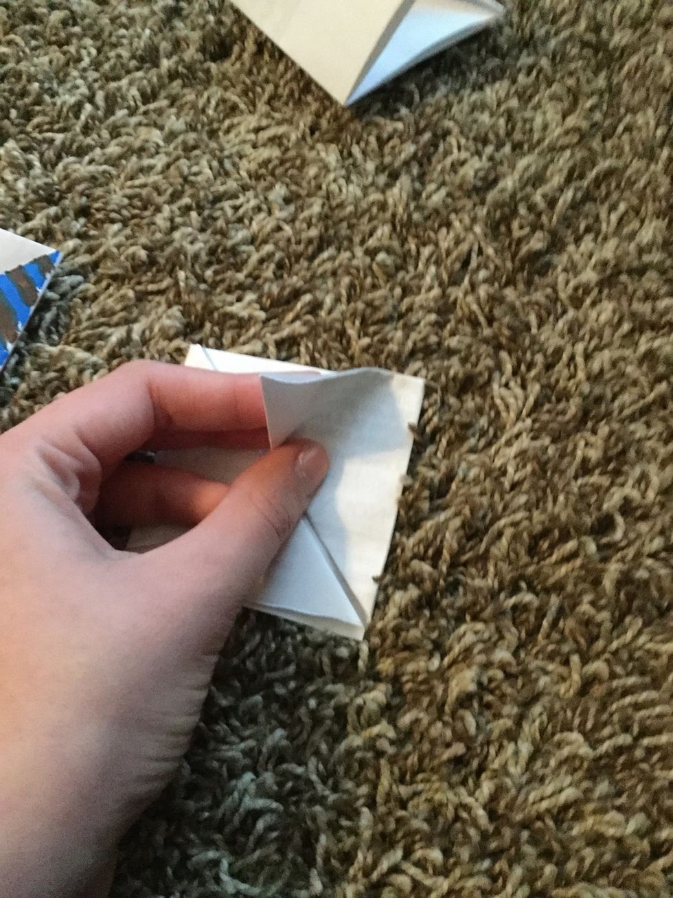 Fold one triangle down into a smaller triangle.