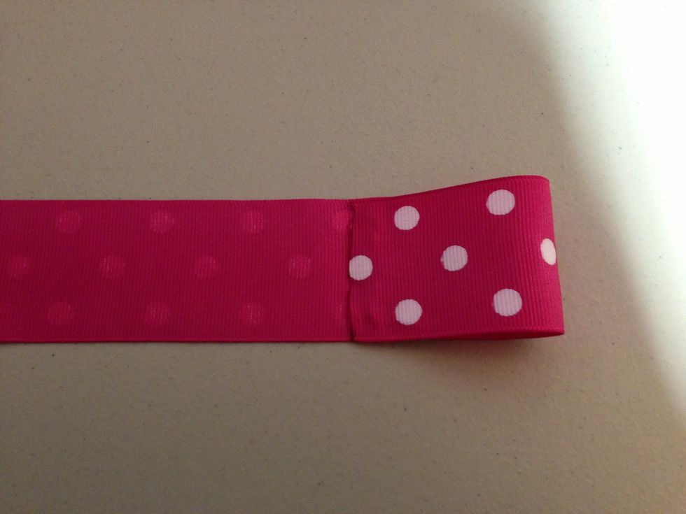 Fold over the side onto the glue. Do not go over the crease line.Do it to the other side and then repeat on the other ribbon.
