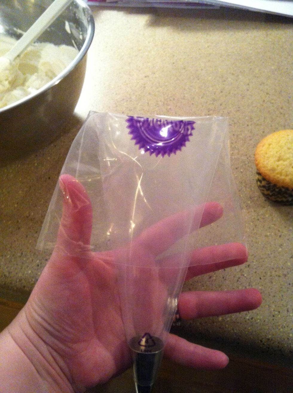 Fold over the top of the bag until the Wilton symbol is folded in half.