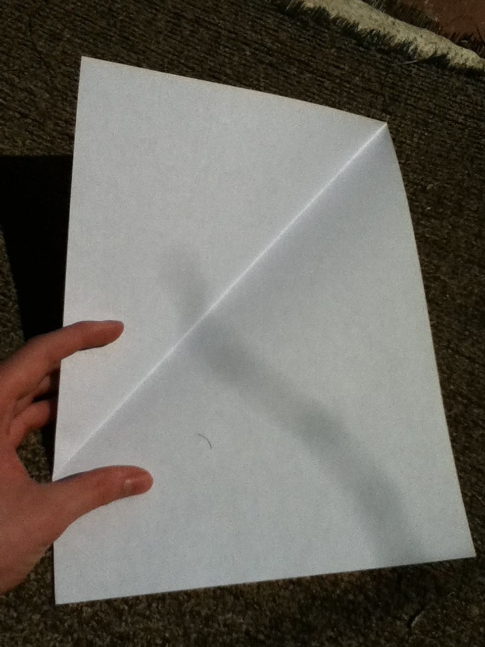Fold paper like so, bringing the corner evenly down to the opposite side.