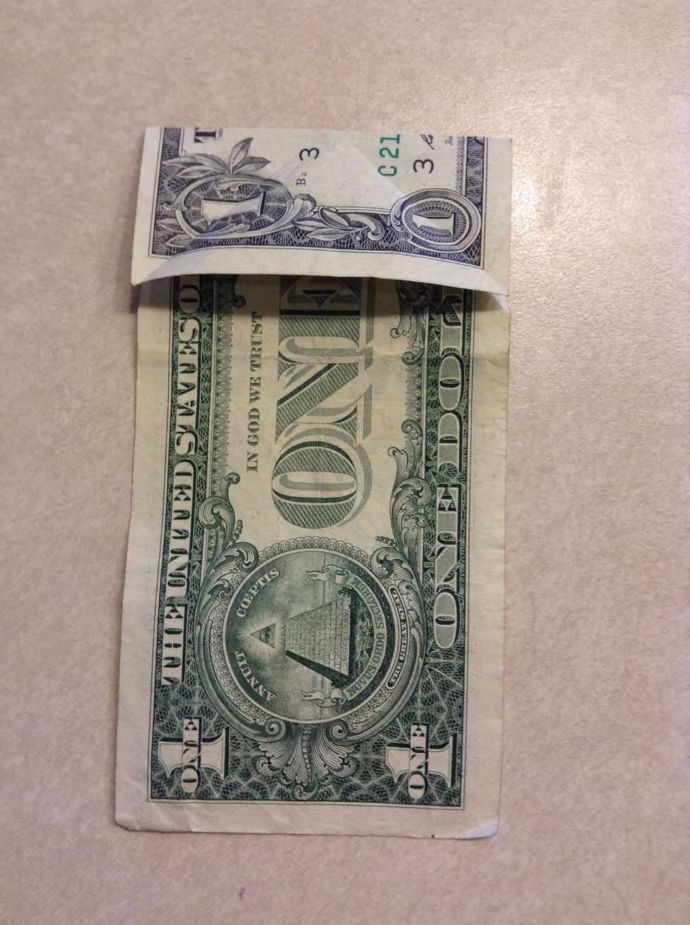 Fold the bill down so that the crease lies on the point of the triangle