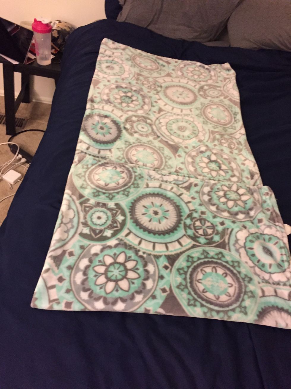 Fold the blanket again so that the shorter side of the blanket meets the middle of the blanket.