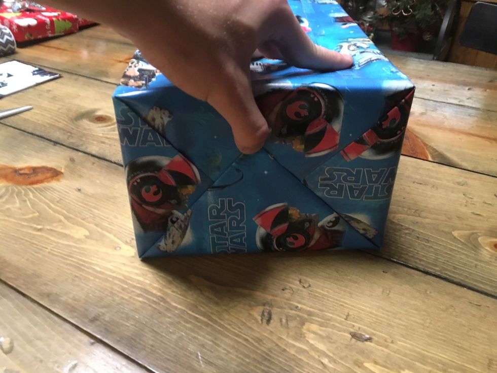 Fold the bottom flap up. Tape the wrapping paper down to secure it in place.