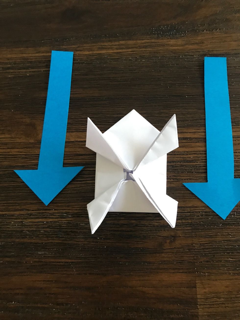 Fold the bottom legs of the frog downward and on an angle.